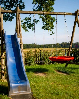 Spielplatz mit Rutsche und Schaukel im Garten